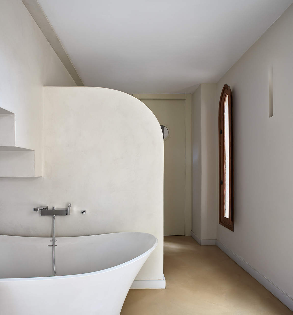 Large microcement walk-in shower with tall ceiling and arched entry — luxury bathroom Los Angeles
